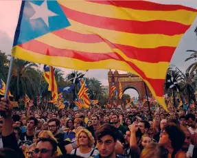  ?? AFP ?? Carles Puigdemont, presidente della Generalita­t, durante il discorso in Parlamento. A destra, gli indipenden­tisti in piazza a Barcellona