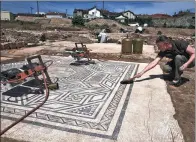  ?? JEAN-PHILIPPE KSIAZEK / AGENCE FRANCE-PRESSE ?? An archaeolog­ist works on a mosaic at the site near Vienne, eastern France.