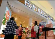  ?? MARSHALL GORBY / STAFF ?? Cheyenne Water and Natalie Herrfurth, employees at Bath and Body Works at the Dayton Mall, greet customers as they walk into the store in December.