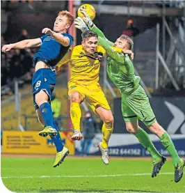  ??  ?? Dundee’s Danny Johnson wins the air battle at Dens Park