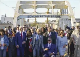  ?? AP photo ?? President Joe Biden walks across the Edmund Pettus Bridge in Selma, Ala., on Sunday to commemorat­e the 58th anniversar­y of “Bloody Sunday,” a landmark event of the civil rights movement. With Biden is Rep. Terri Sewell, D-Ala., the Rev. Al Sharpton and the Rev. Jesse Jackson.