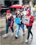  ?? JEFF MCINTOSH THE CANADIAN PRESS ?? The rain didn’t deter Calgary protesters as they marched.