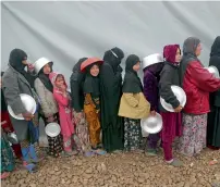  ?? AP ?? Displaced Iraqis line up to receive some 10km south of Mosul. — food at a camp in Hamam Al Alil,