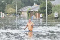  ??  ?? A man wades through a flooded street in Ascension Parish, Louisiana, US. — Reuters photo