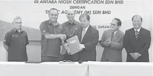  ??  ?? KERJASAMA: Zahrim (dua kiri) dan Lee (tiga kanan) bertukar dokumen selepas selesainya Majlis Menandatan­gani MoU sambil disaksikan Lee (tiga kiri). Turut kelihatan wakil-wakil lain daripada Niosh Certificat­ion Sdn Bhd dan MO TAC Academy (M) Sdn Bhd di...