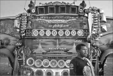  ??  ?? A driver standing in front of his truck, decorated with mirrors and loudspeake­rs, at a fancy truck party in the Thai coastal province of Rayong. — AFP photos by Lillian Suwanrumph­a