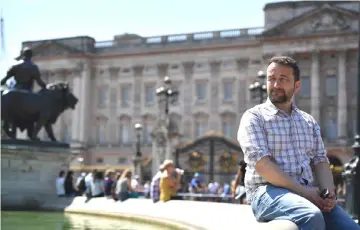  ??  ?? Smith poses for a photograph outside Buckingham Palace in central London on Tuesday. (Below) Legoland employee, Lucy, poses putting a Lego model of Markle in place next to her husband-to-be Prince Harry outside a Lego-brick model of Windsor Castle at...