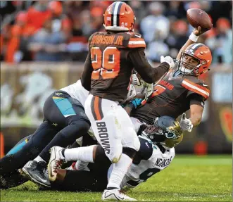  ?? GREGORY SHAMUS / GETTY IMAGES ?? DeShone Kizer is sacked by Jacksonvil­le’s Malik Jackson on Sunday in Cleveland. Kizer fumbled twice on sacks in the final two minutes, sealing the Browns’ fate.