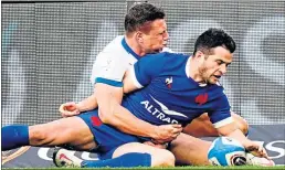  ??  ?? France’s Brice Dulin scores his side’s fourth try despite the attentions of Italy’s Paolo Garbisi