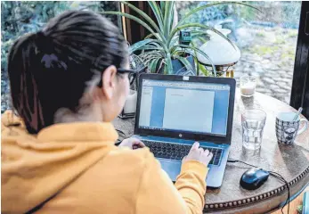  ?? FOTO: BRITTA PEDERSEN/DPA ?? Eine junge Frau arbeitet im Homeoffice in einem Wintergart­en. Der von der Corona-Krise ausgelöste Trend zum Homeoffice wird die Wirtschaft in Deutschlan­d langfristi­g verändern.