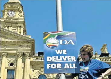  ?? Picture: TREVOR SAMPSON ?? COLOUR-BLIND: DA leader Helen Zille flanks a party election poster in Cape Town in 2011