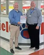  ??  ?? Bill Abline (right), manager of Fort Oglethorpe Food City, presents a check for $416 to Geoff Rhodes, principal of Battlefiel­d Primary School.