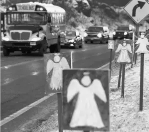  ?? JESSICA HILL/ THE ASSOCIATED PRESS ?? A bus passes 26 angels honouring the victims of December’s shooting massacre at Sandy Hook Elementary School in Newtown, Conn.
