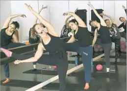  ??  ?? POP PHYSIQUE instructor Katie Schaar gives direction while taking her class through a series of barre-focused exercises at the Highland Park locale.