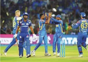  ?? AFP, Courtesy: IPL ?? Mumbai Indians opener Suryakumar Yadav takes the aerial route during the IPL match against Rajasthan Royals at the Sawai Mansingh Stadium in Jaipur yesterday. Right: Dhawal Kulkarni of Rajasthan celebrates the wicket of Evin Lewis of Mumbai. Mumbai...