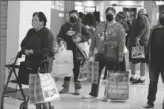  ?? RINGO H.W. CHIU/AP ?? BLACK FRIDAY SHOPPERS WEARING FACE MASKS wait in line to enter a store at the Glendale Galleria in Glendale, Calif., Nov. 27, 2020.
