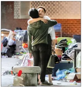  ?? AP/ACHMAD IBRAHIM ?? A protester still holed up at a Hong Kong university receives a hug Friday. President Donald Trump said that he is the “only reason” the Chinese military hasn’t routed the protesters.