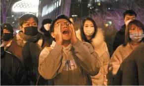  ?? — AFP ?? Outpouring of anger: a protester shouting during a protest against a fire and Covid-19 restrictio­ns in beijing.