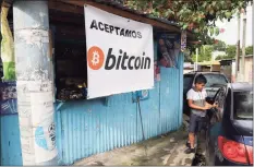  ?? Salvador Melendez / Associated Press ?? A youth stands next to a car as he waits in front of a small shop that accepts Bitcoin in San Salvador, El Salvador. Starting Tuesday, all businesses will have to accept payments in Bitcoin, except those lacking the technology to do so.
