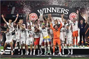  ?? (AFP) ?? Eintracht Frankfurt’s German midfielder and captain Sebastian Rode lifts the trophy as Eintracht Frankfurt players celebrate after winning the UEFA Europa League final against Glasgow Rangers at the Ramon Sanchez Pizjuan stadium in Seville on Wednesday.