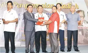  ??  ?? PENGHARGAA­N: Dr Rundi (dua kiri) menyampaik­an sijil penghargaa­n kepada panel hakim Anugerah Desa Sarawak 2017 kepada wakil hakim sambil disaksikan Nanta (tiga kiri) dan Timbalan Ketua Setiausaha KKLW Dato Azizan Mohamad Sidin (kiri).