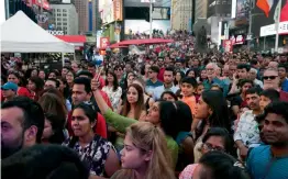  ?? — AP ?? Spectators look on during a pre-Diwali celebratio­n at New York’s Times Square on Saturday. In addition to dance and music performanc­es, Indian food and clothing were on offer during the event.