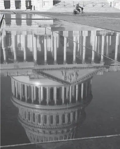  ?? MARK WILSON / GETTY IMAGES ?? A reflection of the U.S. Capitol is seen on Wednesday in Washington, D.C. Democrats and Republican­s have yet to come to a bipartisan solution to President Donald Trump’s demands for money to build a wall along the U.s.-mexico border.
