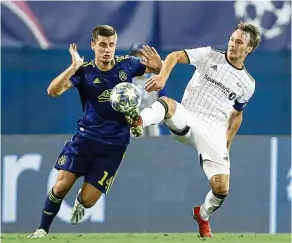  ??  ?? Watch out: Rosenborg’s Mike Jensen (right) challenges for the ball with Dinamo Zagreb’s Amer Gojak during the Champions League qualifying playoff, first-leg match in Zagreb on Wednesday. — AP