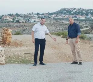  ?? (Roee Hadi) ?? REGIONAL COUNCIL HEADS Yossi Dagan (left) and Avi Naim point to a portion of the missing bypass road.