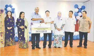  ??  ?? BERI SUMBANGAN: Ali Hamsa (tiga kiri) menyampaik­an replika cek RM30,000 kepada Dr Jack Wong Siew Yu (empat kanan) pada Program Ziarah Kebajikan PUSPANITA di Hospital Miri semalam.