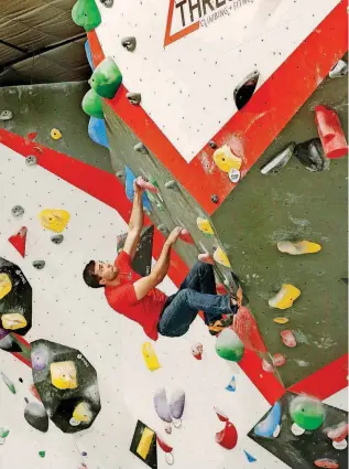  ?? [PHOTO BY JIM BECKEL, THE OKLAHOMAN] ?? Threshold Climbing + Fitness & Yoga co-owner John Tarkington scales a wall in the facility’s bouldering area.