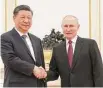  ?? Associated Press ?? Chinese President Xi Jinping, left, and Russian President Vladimir Putin shake hands before their talks in Moscow.