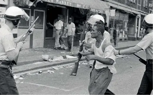  ??  ?? Le 23 juillet 1967, lors des émeutes de Detroit, un homme est arrêté par la police.