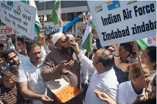 ?? AFP ?? Indians distribute sweets as they celebrate the strike launched by Indian Air Force on a Jaish-eMohammad camp at Balakot in Pakistan, outside a mosque in Mumbai on Tuesday. —