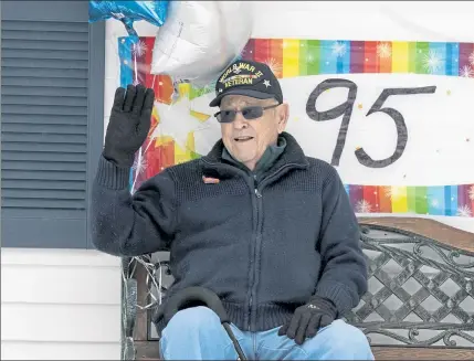  ?? JOHN LOVE PHOTOS / SENTINEL & ENTERPRISE ?? World War II veteran Petty Officer 2nd Class Norman ‘Cookie’ Melanson recently turned 95. He was celebrated on Saturday morning with a parade of cars past his home in Leominster. Below, Leominster’s Veterans Service Director Rick Voutour waves to Melanson.