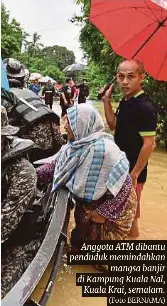  ?? (Foto BERNAMA) ?? Anggota ATM dibantu penduduk memindahka­n mangsa banjir di Kampung Kuala Nal, Kuala Krai, semalam.