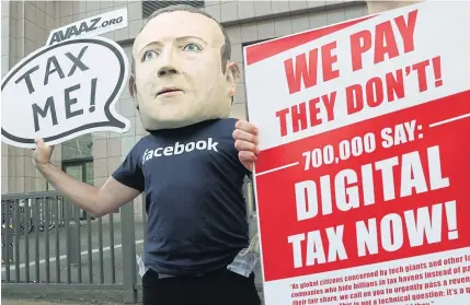  ??  ?? An activist wearing a mask depicting Facebook CEO Mark Zuckerberg demonstrat­es in front of the European Council in Brussels yesterday.