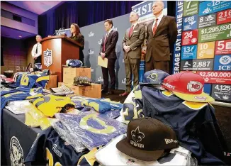  ?? CURTIS COMPTON / CCOMPTON@AJC.COM ?? Fake NFL merchandis­e covers a table as the National Football League and law enforcemen­t agencies announce the latest results of seizures of counterfei­t game-related merchandis­e and tickets during a press conference at the Georgia World Congress Center on Thursday.