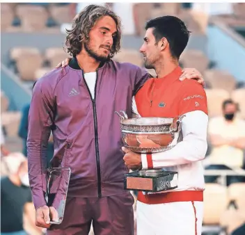  ?? FOTO: THIBAULT CAMUS/AP ?? Sieger und Verlierer vereint: Der French-Open-Gewinner Novak Djokovic (r.) und sein Finalgegne­r Stefanos Tsitsipas umarmen sich, nachdem sie ihre Trophäne bekommen haben.