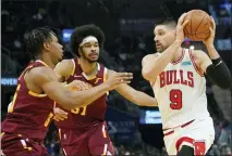  ?? TONY DEJAK — THE ASSOCIATED PRESS ?? Chicago Bulls’ Nikola Vucevic (9) drives past Cleveland Cavaliers’ Isaac Okoro (35) and Jarrett Allen (31) in the first half of an NBA basketball game Dec. 8 in Cleveland.