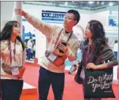  ?? GAO ERQIANG / CHINA DAILY ?? A volunteer gives a participan­t directions at the expo.