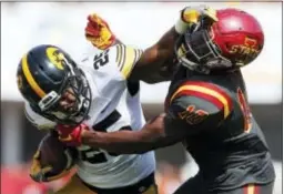  ?? CHARLIE NEIBERGALL — THE ASSOCIATED PRESS FILE ?? Iowa running back Akrum Wadley (25) breaks a tackle by Iowa State defensive back Brian Peavy, right, in Ames, Iowa. Wadley averages 170 all-purpose yards from scrimmage per game.