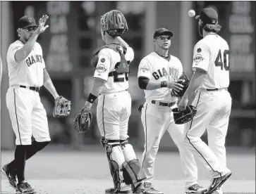  ?? JOSIE LEPE/STAFF ?? Gregor Blanco, second from the right, flips the ball to Madison Bumgarner (40), and Buster Posey high-fives Hunter Pence, left, as the Giants celebrate a 5-0 win and a series sweep over the Washington Nationals on Sunday at AT&T Park.