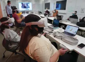  ?? The Associated Press ?? Students at the University of Miami participat­e in a course titled Religion and Sacred Spaces in the Era of Virtual Reality and Artificial Intelligen­ce on April 9, 2019.