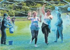  ?? PHOTOS: LINDA ROBERTSON ?? Painted with powder . . . Kate GidlowBlac­k (left) and Ruby Faragher run through a paint station.