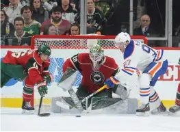  ?? (Reuters) ?? MINNESOTA WILD goalie Devan Dubnyk makes a save but gives up the rebound as Edmonton Oilers forward Connor McDavid (right) reaches for the loose puck during the third period at Xcel Energy Center on Friday. The Wild won 3-2 in a shootout over the Oilers.