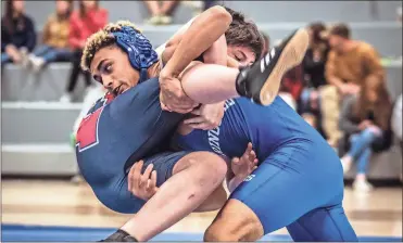  ?? / Courtney Couey, Ringgold Tiger Shots ?? Ringgold’s Destin Troutman lifts Heritage’s Chris Corvin as he looks for a takedown during their 180-pound bout last week.