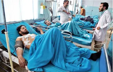  ?? — AFP photo ?? Wounded Afghan men receive treatment at the Wazir Akbar Khan hospital a day after a suicide attack on a religious celebratio­n in Kabul.