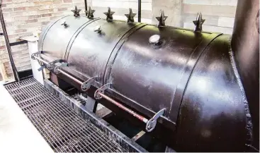  ?? J.C. Reid photos ?? Tejas Chocolate Craftory’s offset barrel smoker is mostly exposed to the elements.