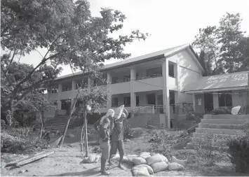  ?? RAFFY T. CABRISTANT­E ?? Constructi­on workers continue finishing a school building at the Ong Chee Tee High School in Bacong town, which has been under constructi­on since 2014.